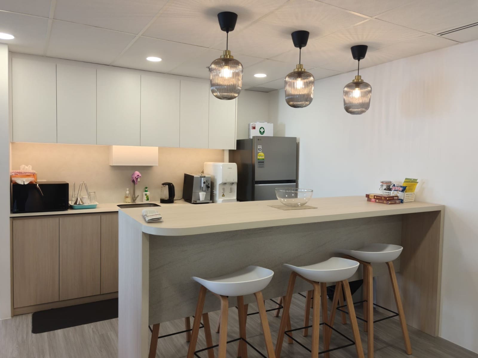 Pantry with a curved island, three pendant lights and white cabinets, OUE Downtown 1, office by Metadesign Interior