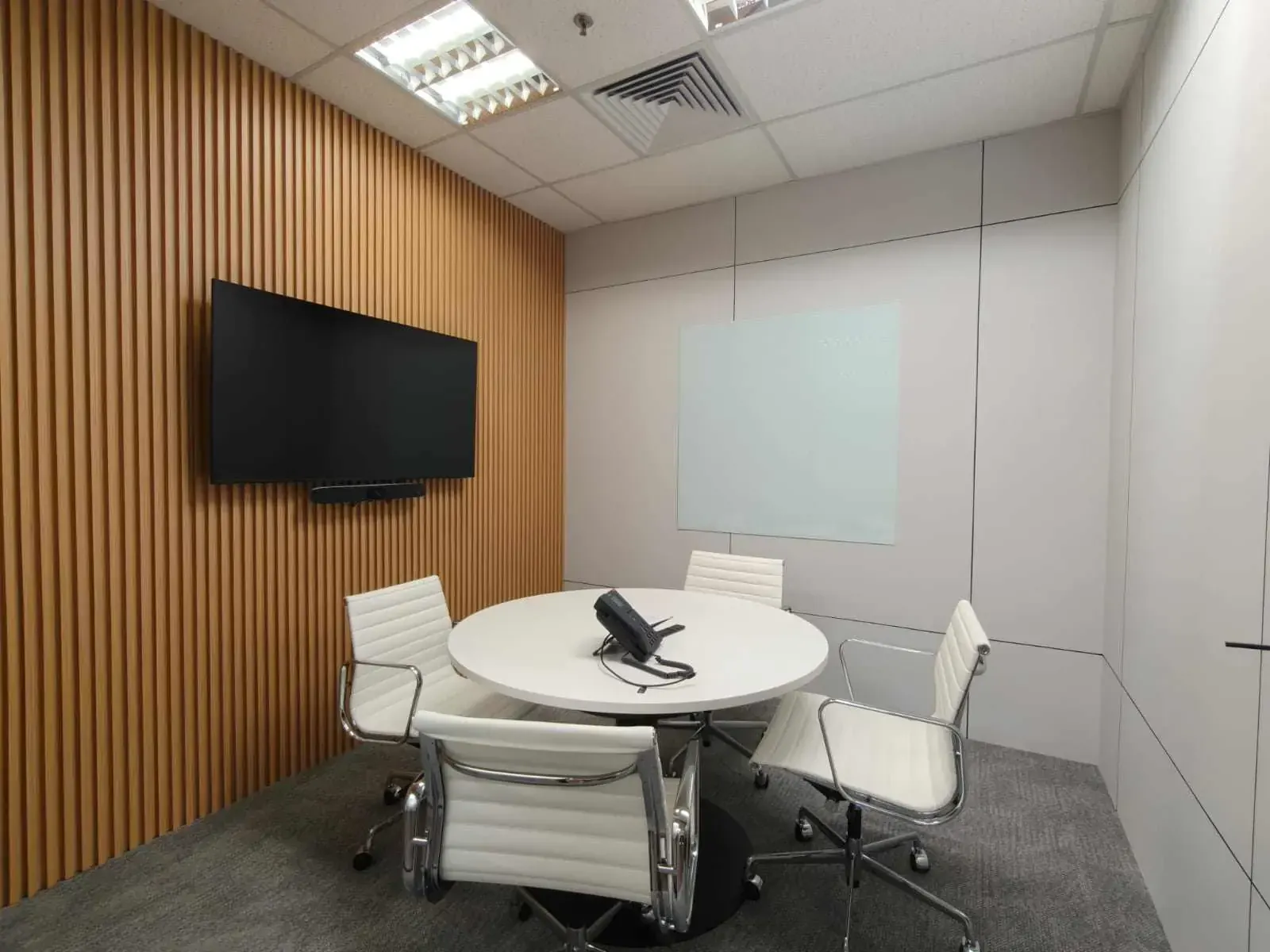 Small meeting room with timber slat wall and wall panels after an office renovation in Singapore