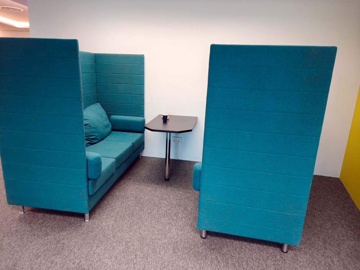 Two high-backed teal seats around a small table. The Signature, AkzoNobel office.